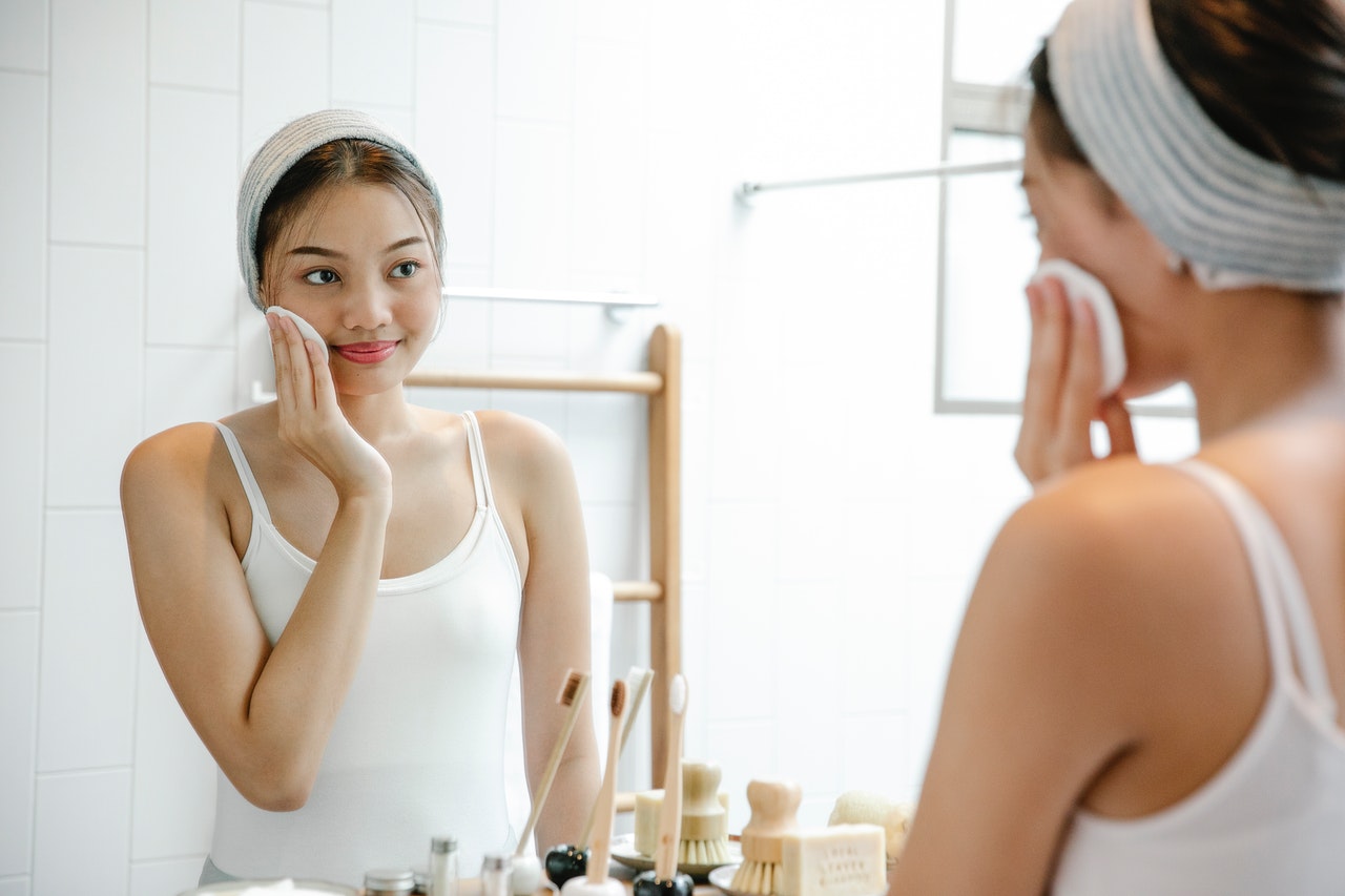 一名女士對着鏡子護膚